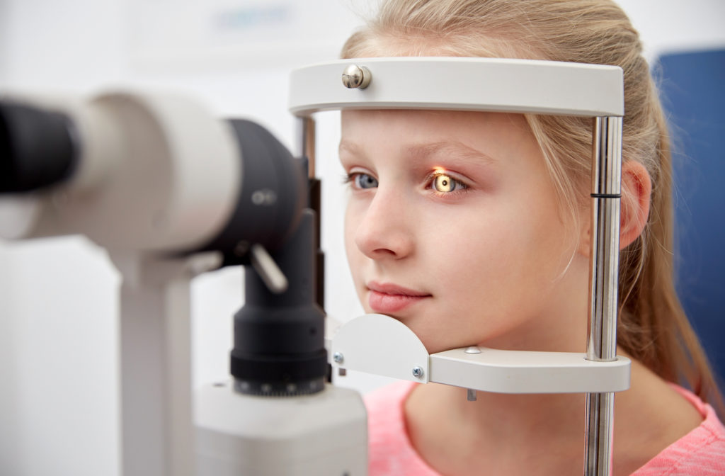 Young girl undergoing eye exam at optometrists office with tonometer