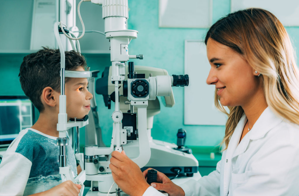 Young boy with eye doctor undergoing eye exam with slit lamp