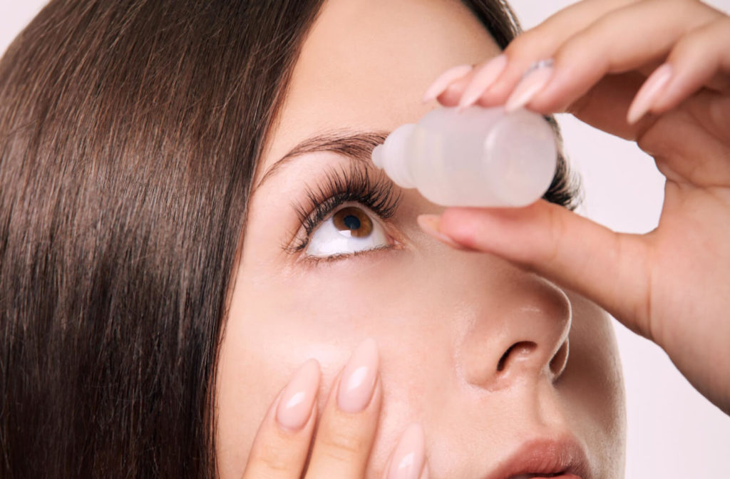 a woman applying atropine eye drops to her right eye