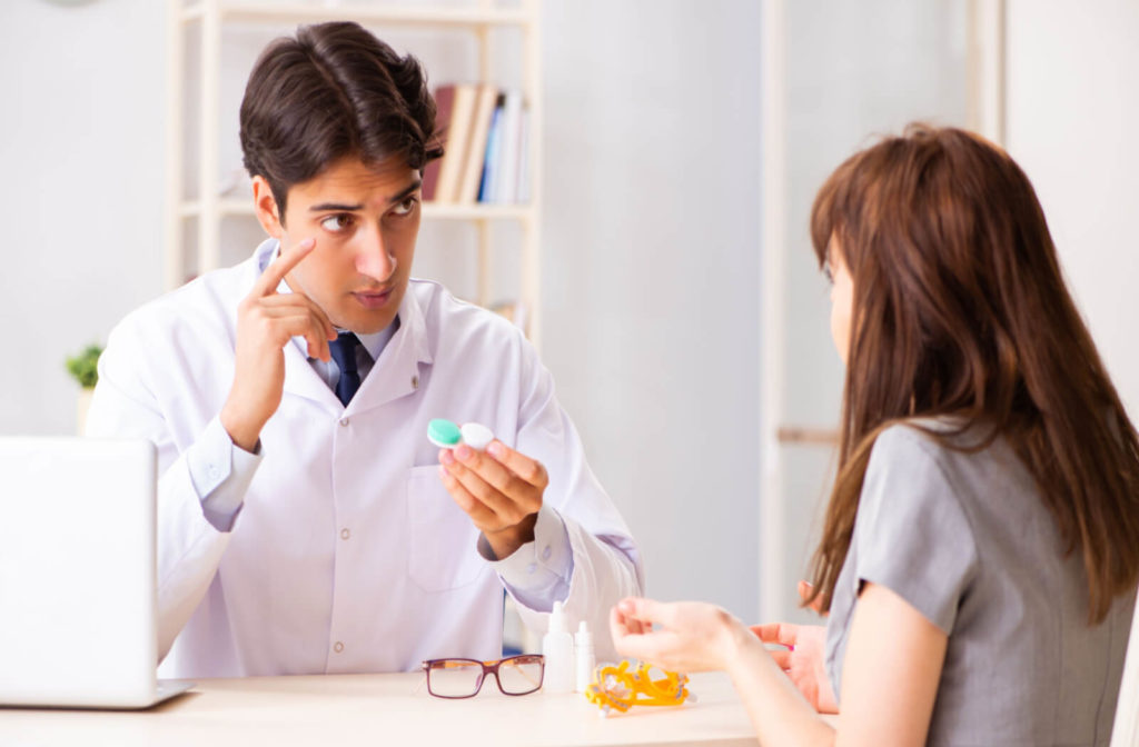 eye doctor helps a patient with a contact lens fitting
