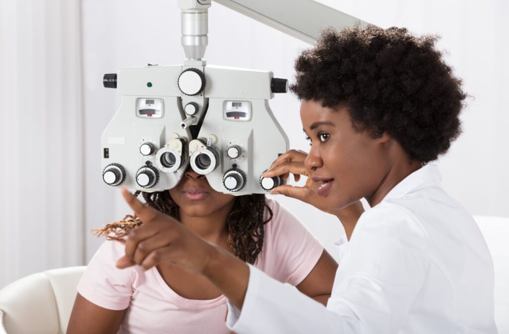 A patient sits behind the phoropter while following the optometrist's instructions.