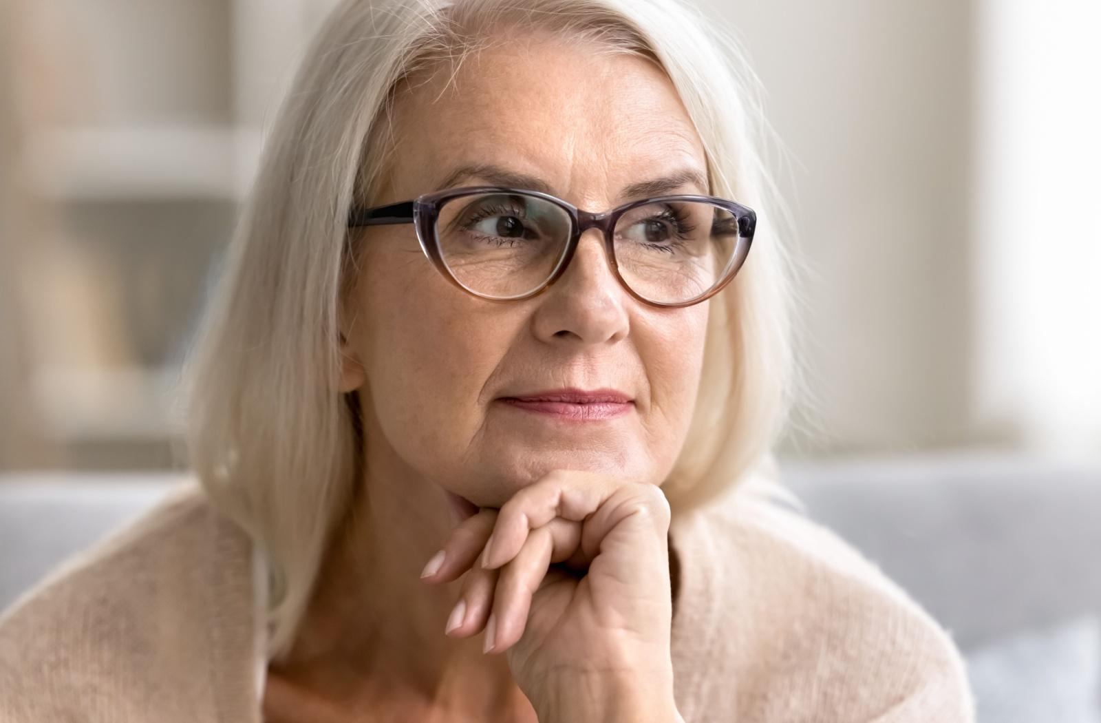 A senior person wearing trendy black framed glasses that suit their face